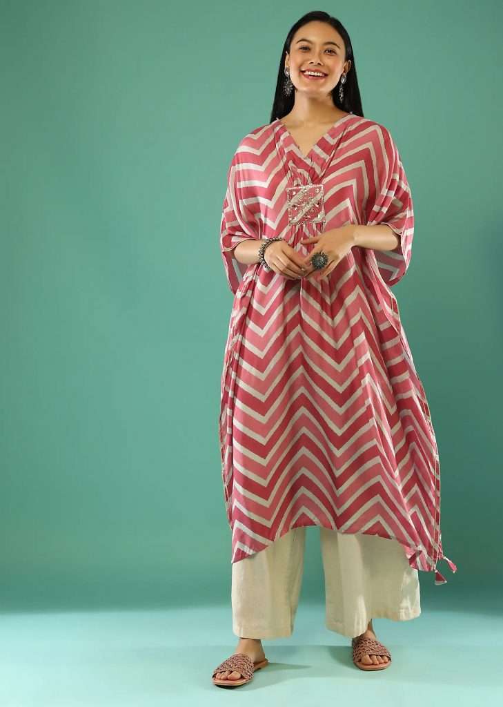 A woman poses for a photo wearing a dark pink and brown kaftan with tie dye leheriya print