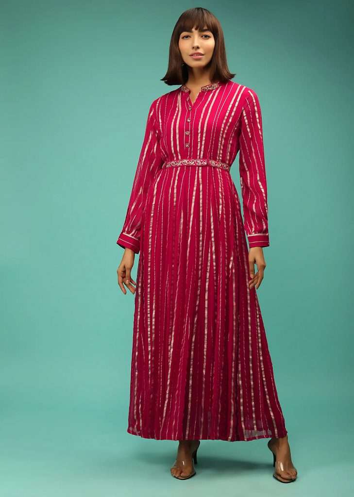 A woman wearing a Queen pink dress in georgette with Lurex stripes and embroidered belt poses for a photo