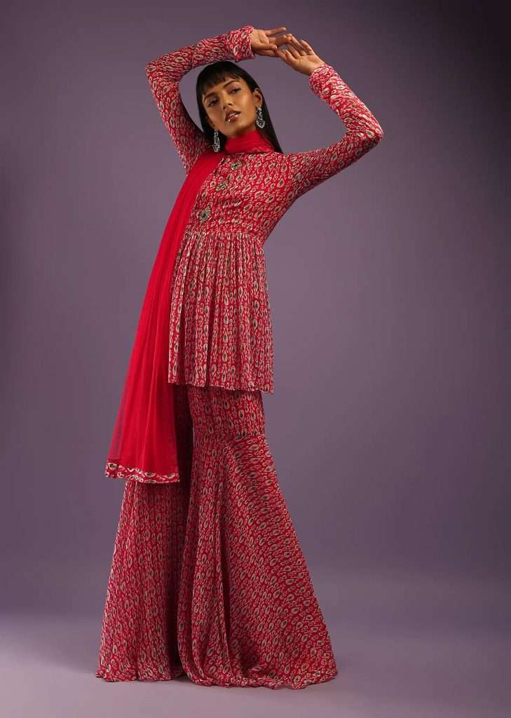 A woman for photo wearing Burberry red sharara suit in georgette with all over print and churidar sleeves