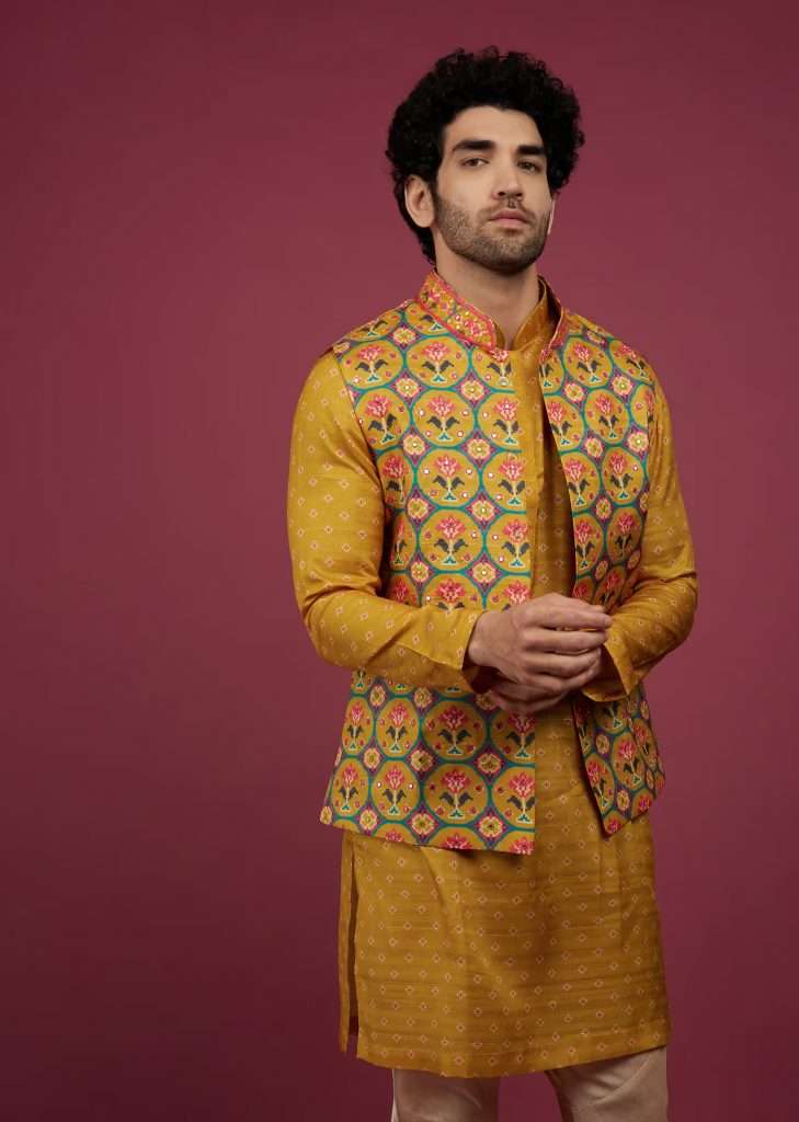 A mother poses for a photo wearing a golden yellow silk patola printed bandi with kurta set.