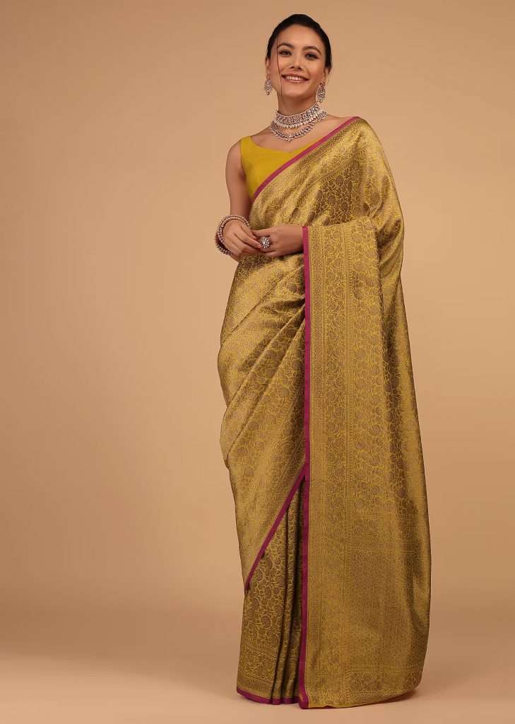 A woman photographed in a Kalki golden rod yellow sari with pure banarasi silk in Upada zari wave floral mesh work