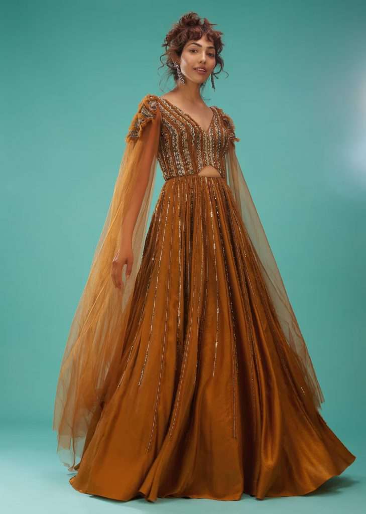 A woman poses for a photograph in a Kalki Golden Oak yellow ball gown with ruffle frills and embroidery