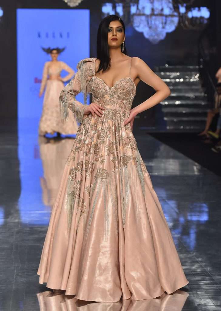 A woman posing for a photo in a Kalki Baroque gown with embellished sleeves