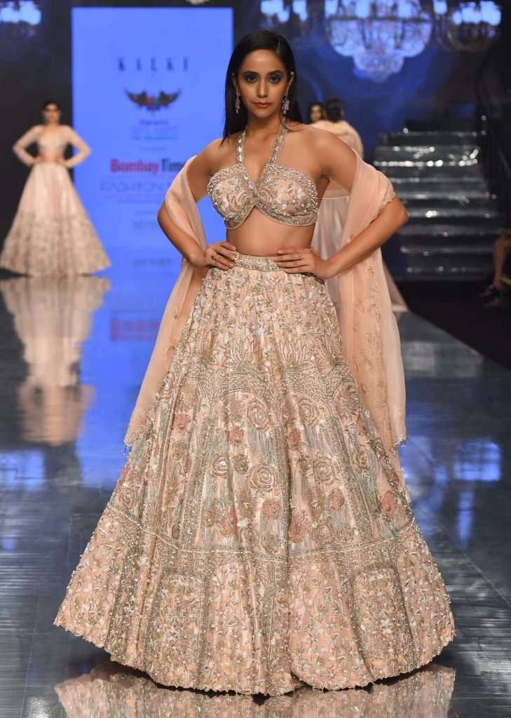 A woman is photographed wearing Kalki festive silver pink bella lehenga set with embroidery and halter blouse