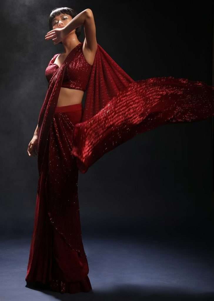 Women poses in Burgundy Red Ready Pleated Saree In Crepe With Sequins Embellished Pallu, Frill On The Hemline And Ready Blouse