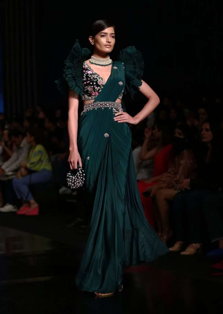 Women poses in Bottle Green Ready Pleated Saree With A Colorful Hand Embroidered Blouse With Fancy Layered Frill Sleeves