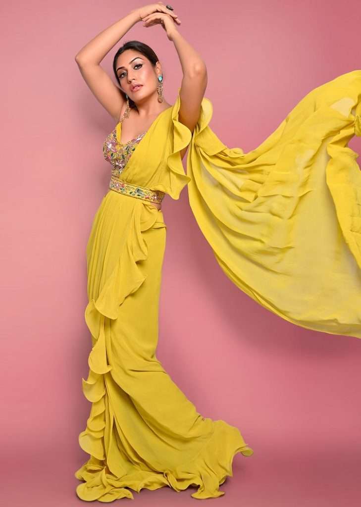 Women poses in Surbhi Chandna In Kalki Citrus Ready Pleated Ruffle Saree With Multi-Color Floral Hand Embroidered Blouse