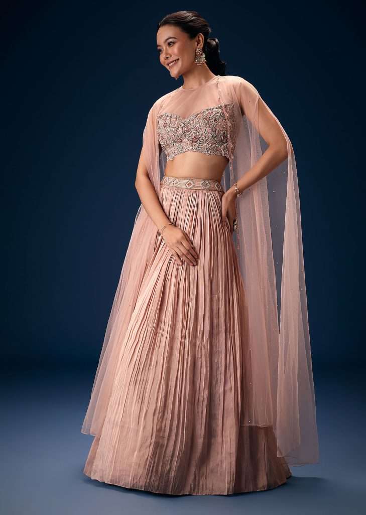 Peach Ruched Lehenga With Embroidered Blouse and Net Cape
