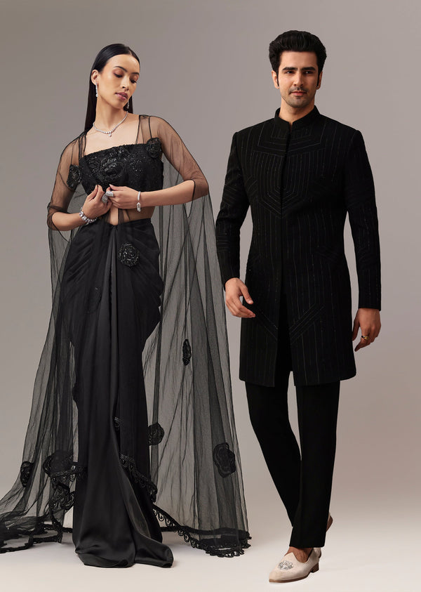Midnight Duo Couple Set – Black Satin Indo-Western Crop Top And Draped Skirt for Her And Black Cutdana Indo-Western Suit for Him